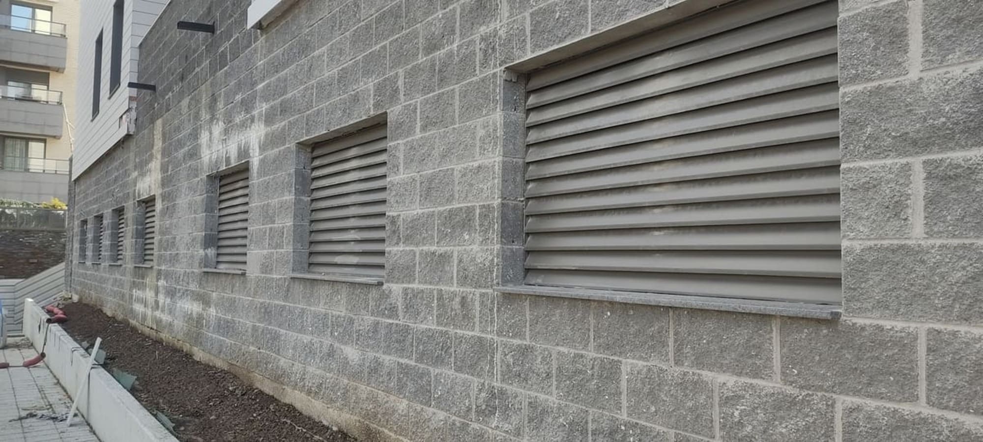 Revestimiento de fachada con lamas metálicas de ventilación en obra por Kronos SL