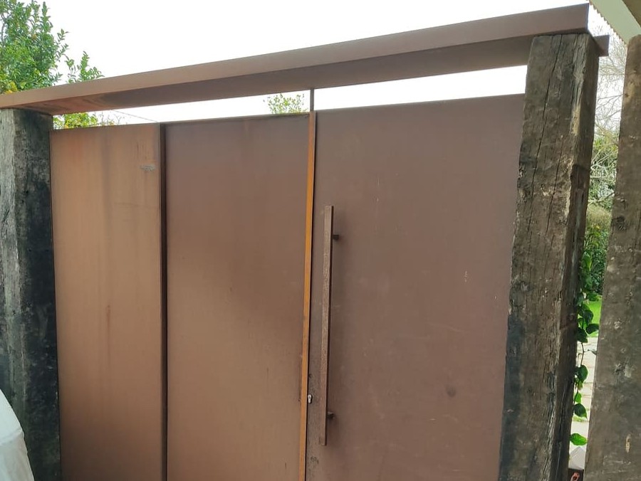 Puerta de acceso en acero corten con postes de madera fabricada por Kronos SL, Bizkaia