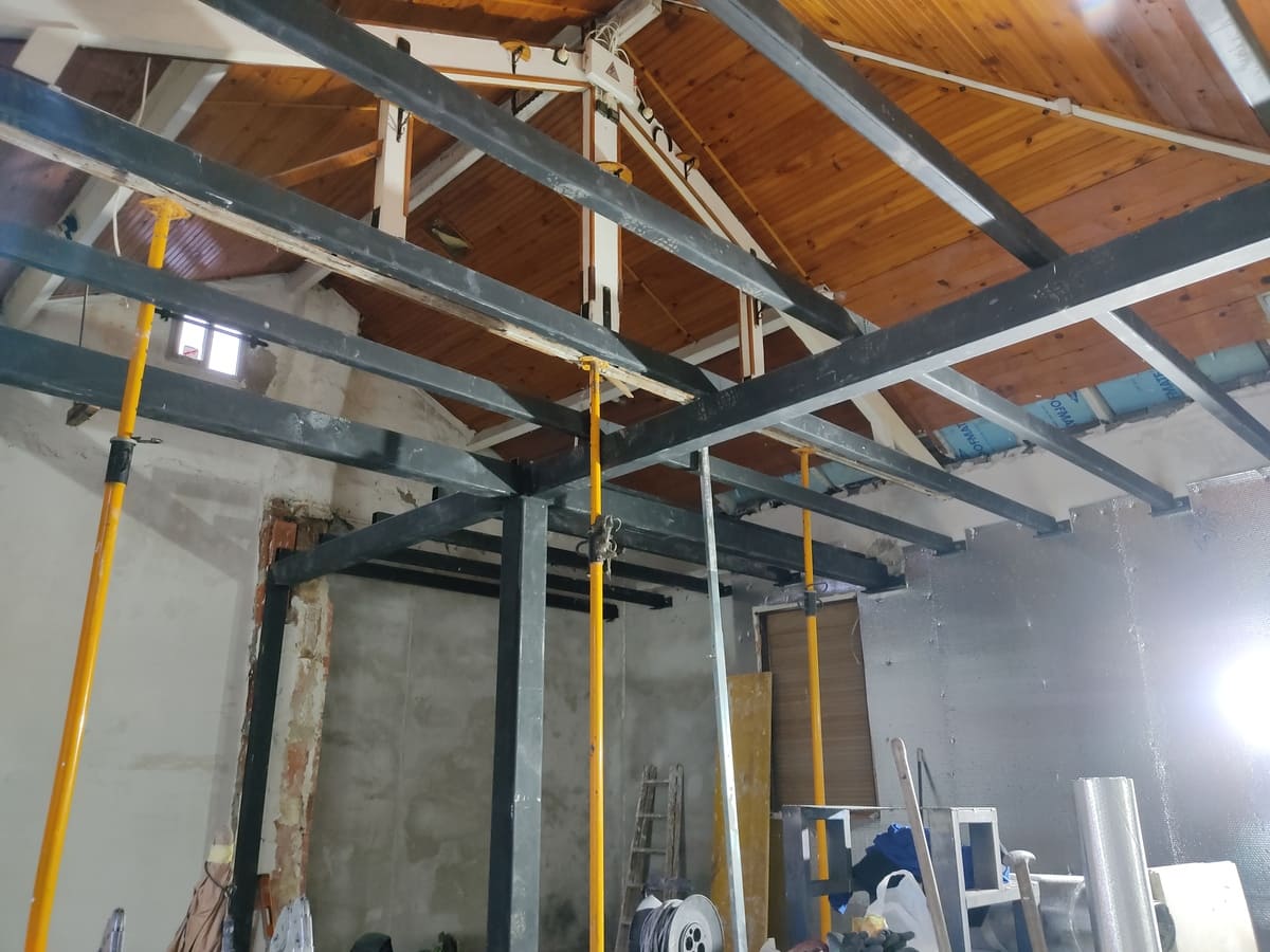 Estructura de vigas de acero en rehabilitación de vivienda con techo de madera por Kronos SL