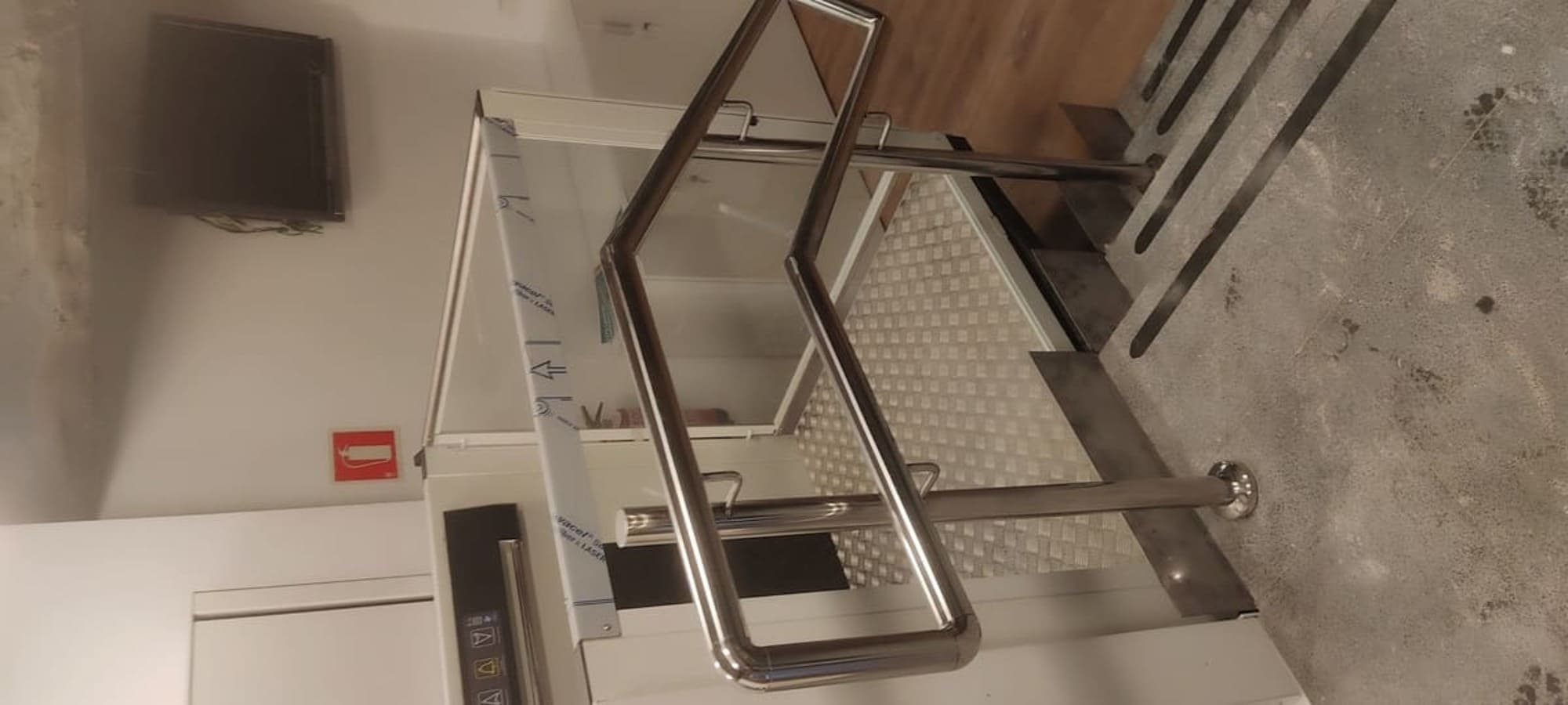 Plataforma salvaescaleras con pasamanos de acero inoxidable instalada por Kronos SL